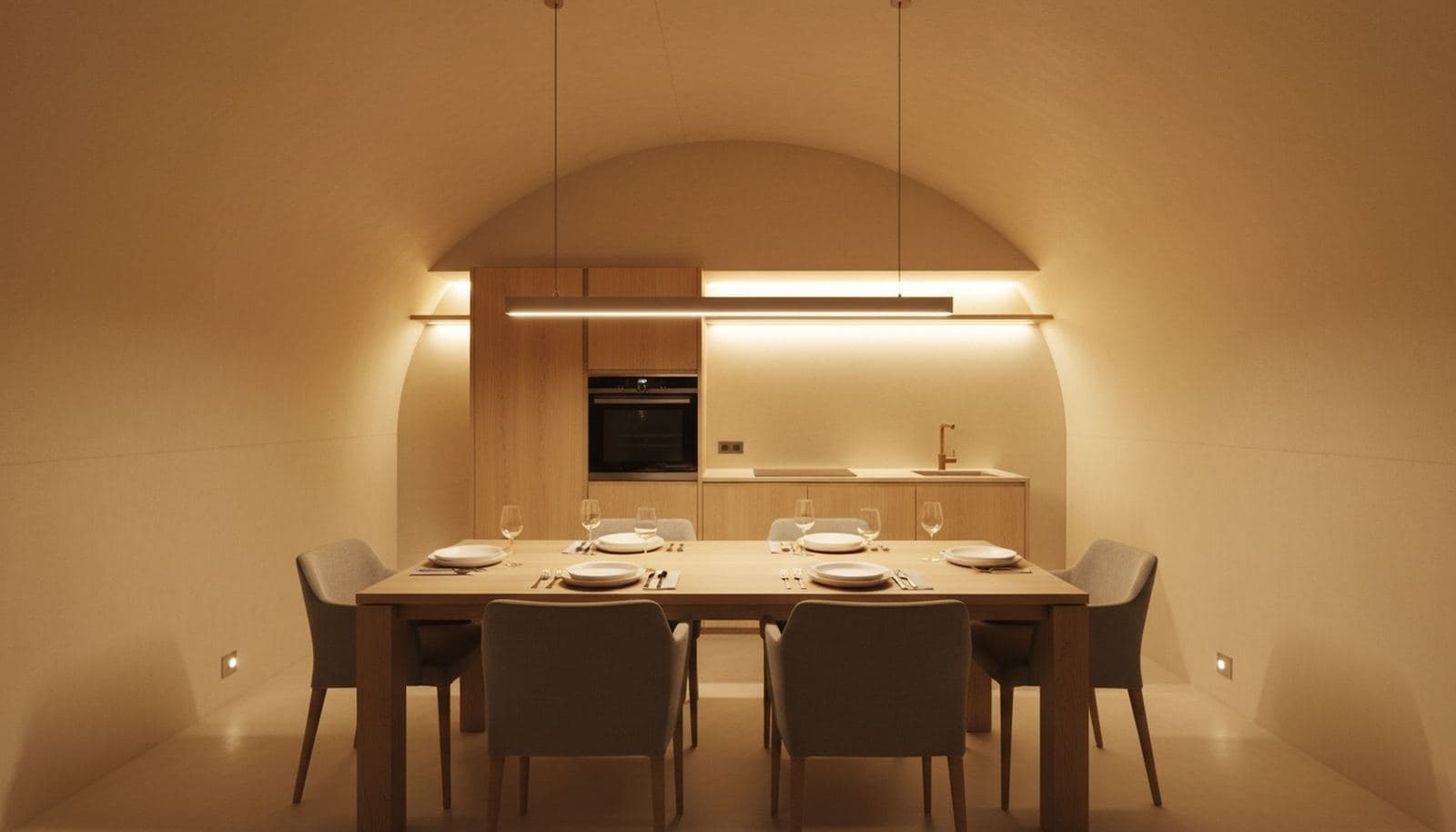 Salle à manger d'un abri enterré, table en chêne et lumière chaude